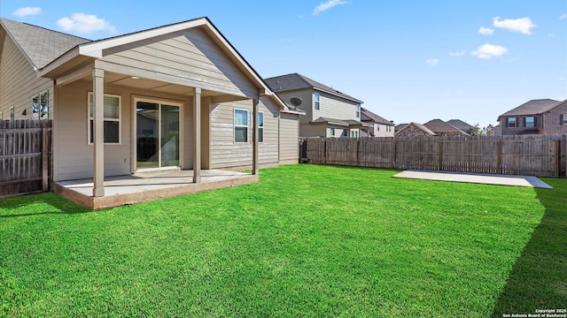 back of house with a lawn and a patio area