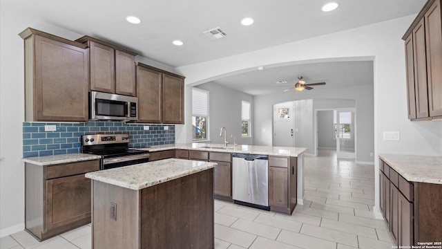 kitchen with a kitchen island, appliances with stainless steel finishes, sink, and kitchen peninsula