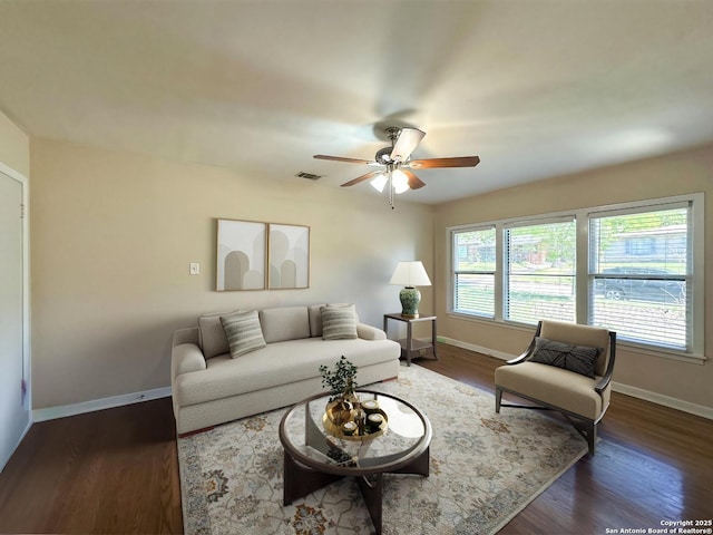 living room featuring ceiling fan and dark hardwood / wood-style flooring