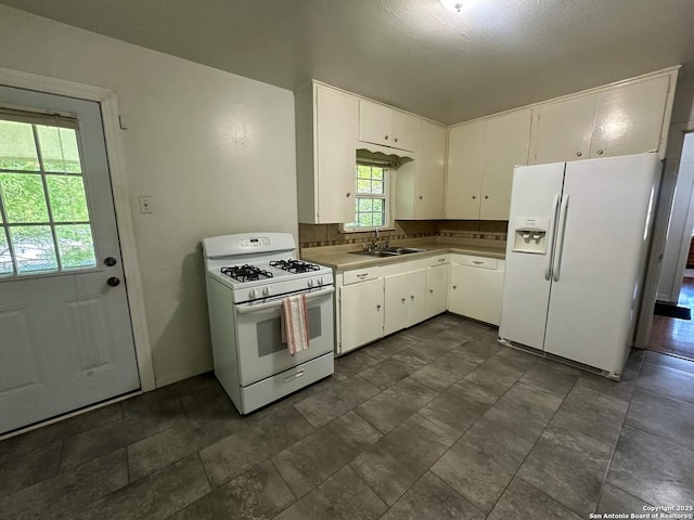 kitchen with white cabinetry, sink, white appliances, and tasteful backsplash