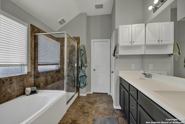 bathroom featuring lofted ceiling, independent shower and bath, and vanity