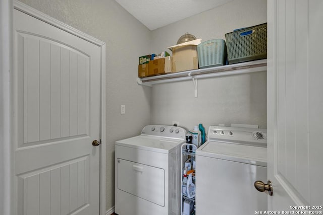 laundry room with separate washer and dryer and a textured ceiling