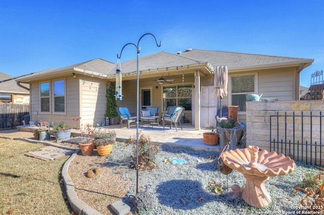 rear view of house featuring ceiling fan and a patio area