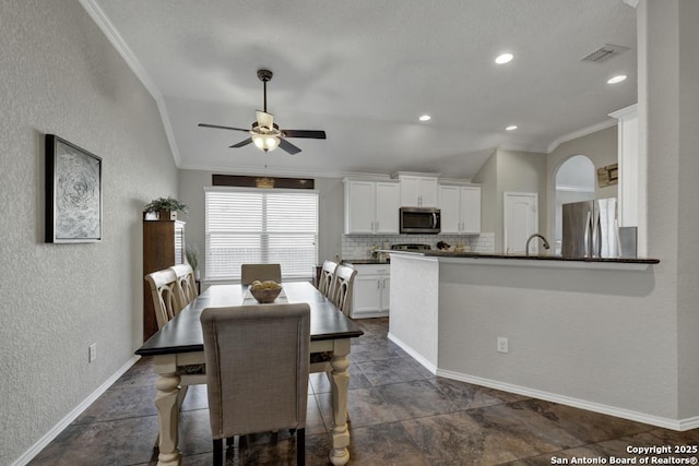 dining space with lofted ceiling, ornamental molding, and ceiling fan