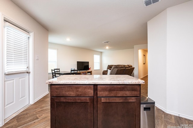 kitchen with dark brown cabinets, dark wood-type flooring, and a center island