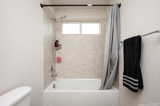 bathroom with shower / tub combo with curtain and toilet