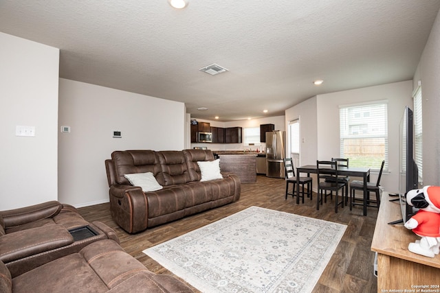 living room featuring dark hardwood / wood-style floors and a textured ceiling