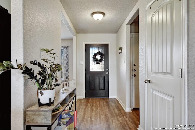 entrance foyer with wood-type flooring and a textured ceiling