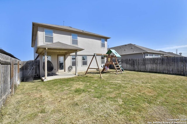 rear view of property with a yard, a playground, and a patio area