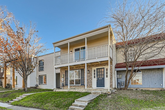 view of front of home featuring a balcony and a front lawn