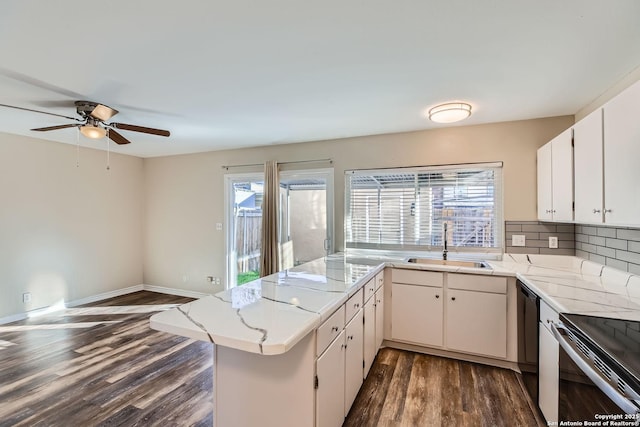 kitchen featuring sink, dishwasher, white cabinets, dark hardwood / wood-style flooring, and kitchen peninsula