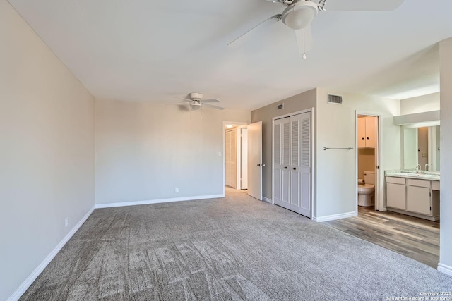 unfurnished bedroom featuring carpet, sink, connected bathroom, and ceiling fan