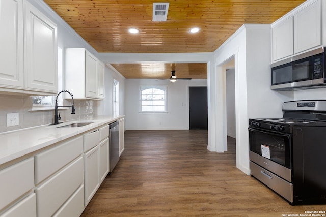 kitchen with stainless steel appliances, white cabinetry, sink, and wooden ceiling