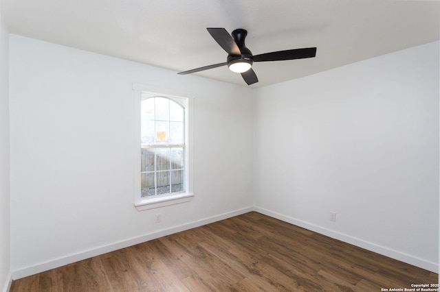 spare room with dark hardwood / wood-style flooring and ceiling fan