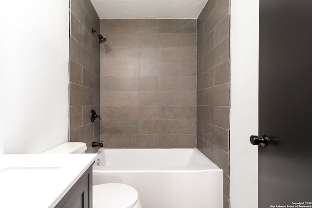 full bathroom with tiled shower / bath, vanity, and toilet