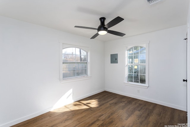 unfurnished room with dark wood-type flooring, ceiling fan, plenty of natural light, and electric panel