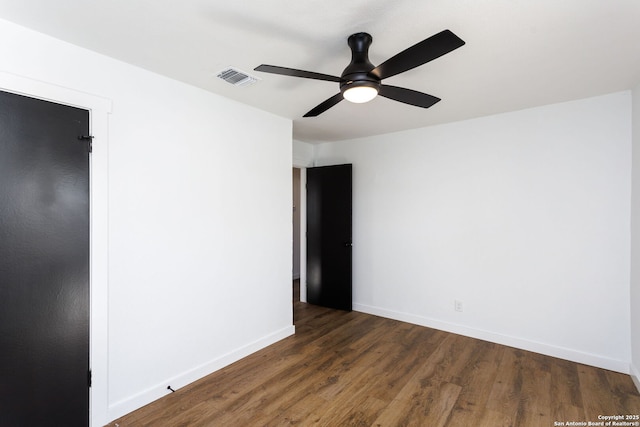 empty room with dark hardwood / wood-style floors and ceiling fan