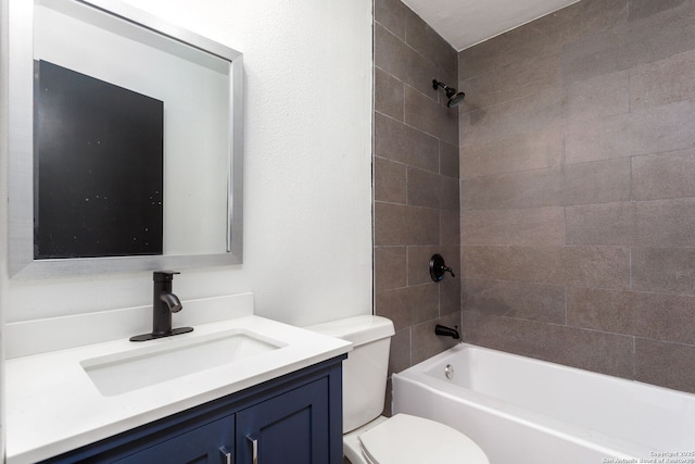 full bathroom featuring tiled shower / bath, vanity, and toilet