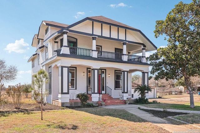 view of front of house with a balcony, a porch, and a front yard