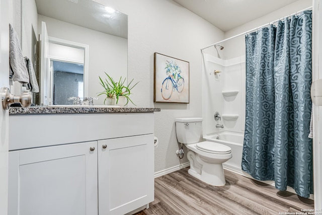 full bathroom featuring hardwood / wood-style flooring, vanity, shower / tub combo, and toilet