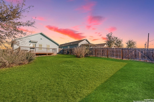 yard at dusk featuring a wooden deck