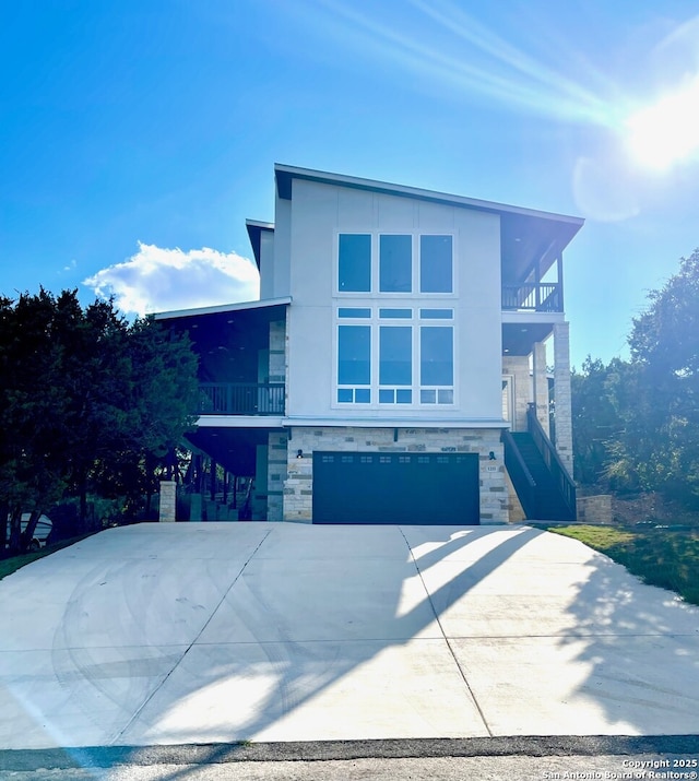 contemporary house featuring a garage and a balcony