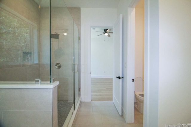 1255 Canyon Lk, Canyon Lake, TX 78133 - bathroom featuring ceiling fan, a stall shower, tile patterned floors, toilet, and baseboards