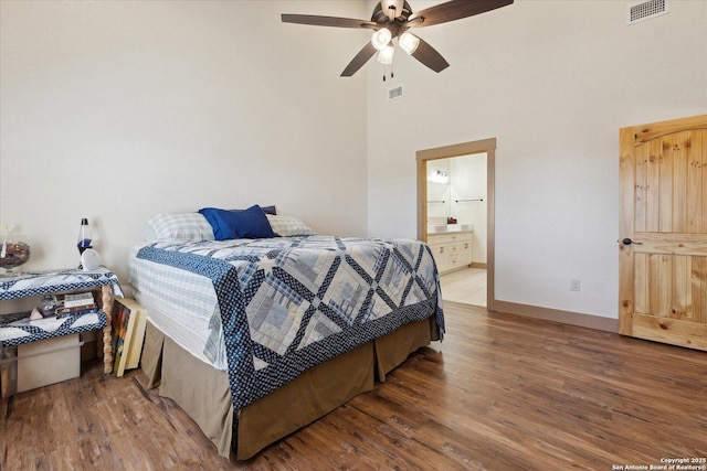 bedroom with ceiling fan, ensuite bath, and wood-type flooring