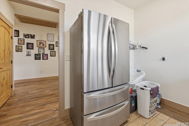 kitchen with light wood-type flooring and stainless steel refrigerator