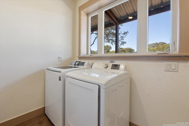 clothes washing area with washing machine and dryer and dark hardwood / wood-style floors