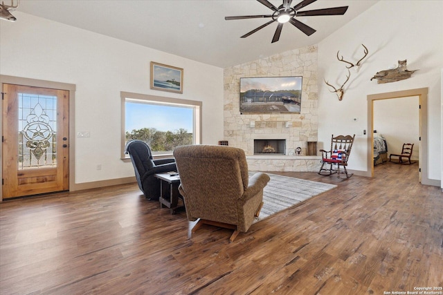 living room with lofted ceiling, hardwood / wood-style floors, a fireplace, and ceiling fan