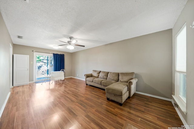 unfurnished living room with dark wood-type flooring, ceiling fan, and a textured ceiling