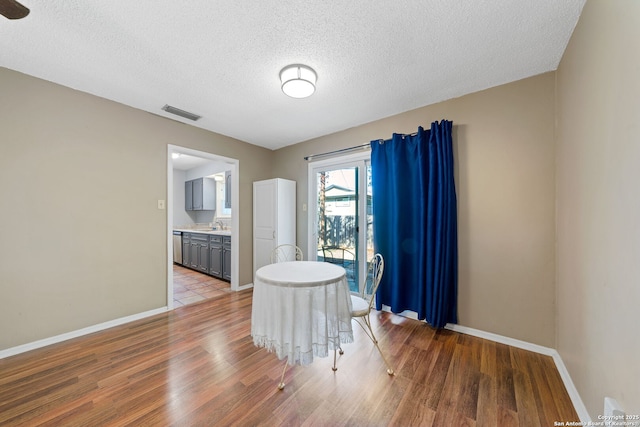 dining area with hardwood / wood-style flooring and a textured ceiling