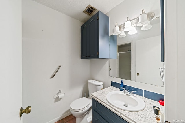 bathroom with vanity, a textured ceiling, tile patterned floors, toilet, and walk in shower