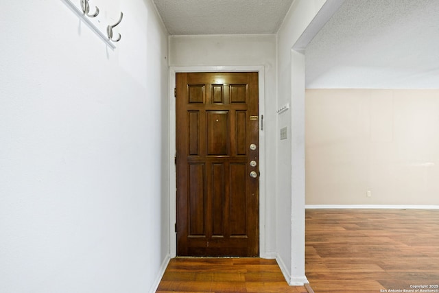 foyer entrance with hardwood / wood-style floors and a textured ceiling