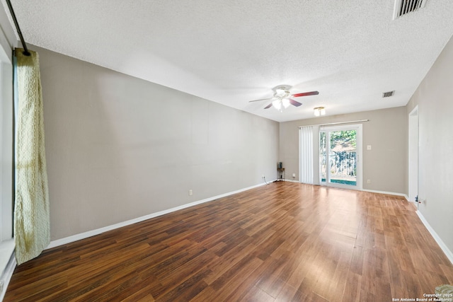 empty room with ceiling fan, dark hardwood / wood-style flooring, and a textured ceiling