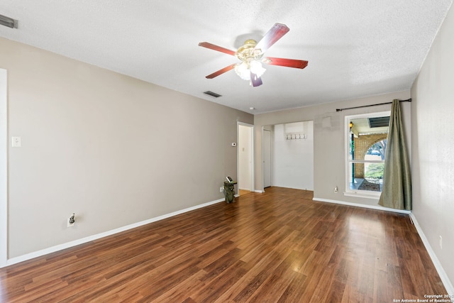 empty room featuring ceiling fan, a textured ceiling, and dark hardwood / wood-style flooring