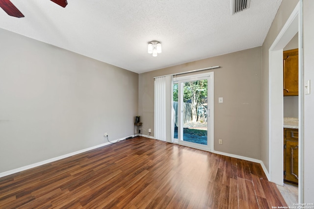 unfurnished room with hardwood / wood-style flooring, ceiling fan, and a textured ceiling