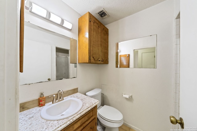 bathroom featuring vanity, an enclosed shower, a textured ceiling, and toilet