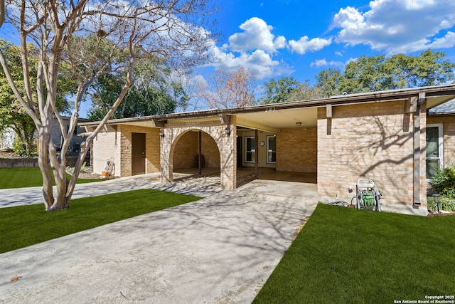 ranch-style home featuring a carport and a front lawn