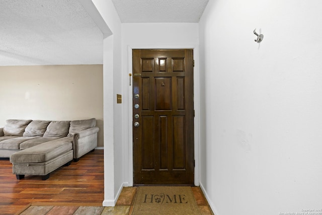 foyer entrance featuring dark hardwood / wood-style floors and a textured ceiling