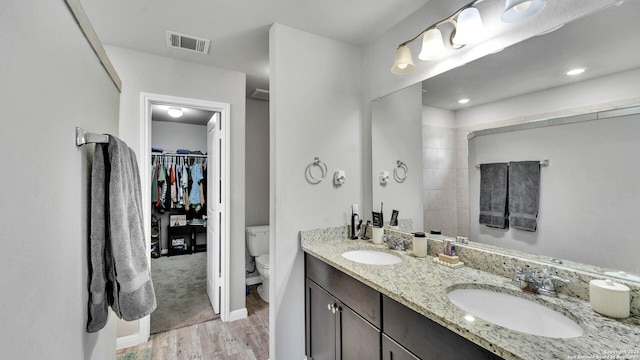 bathroom featuring wood-type flooring, vanity, and toilet