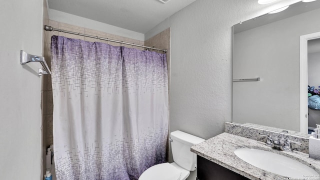 bathroom with vanity, walk in shower, and toilet