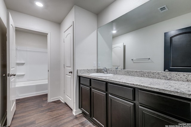 bathroom featuring shower / bathtub combination, vanity, and hardwood / wood-style floors