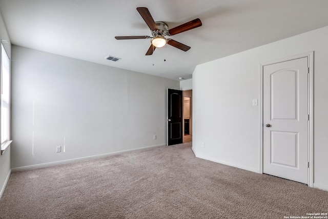 carpeted spare room featuring ceiling fan