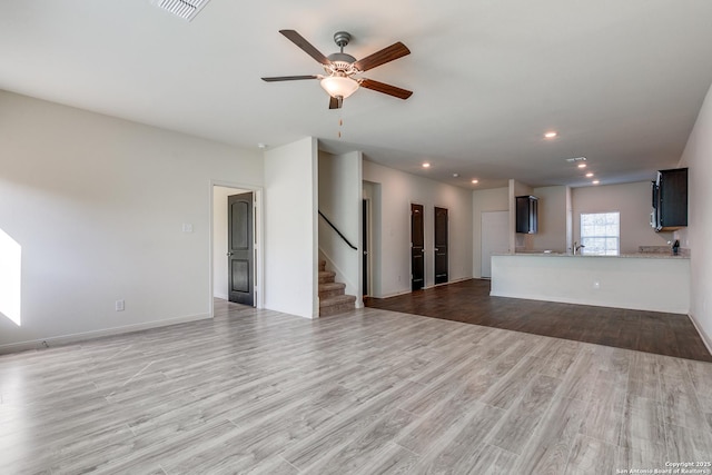 unfurnished living room featuring wood-type flooring and ceiling fan