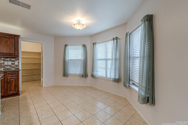 unfurnished dining area featuring light tile patterned flooring