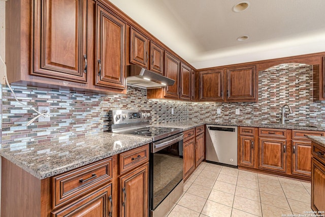 kitchen with light tile patterned floors, sink, stainless steel appliances, light stone counters, and decorative backsplash