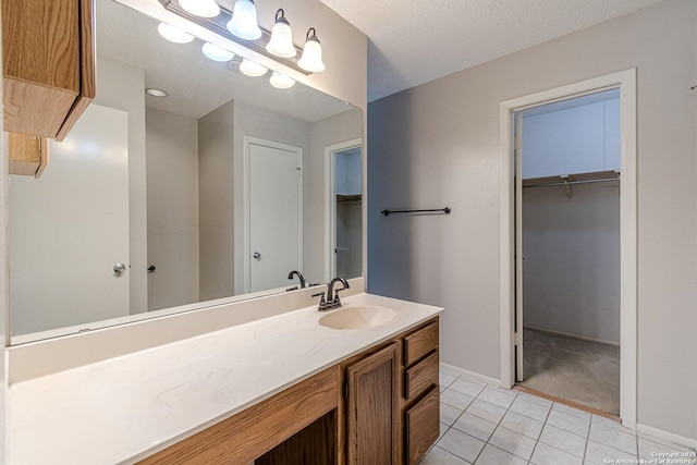 bathroom featuring vanity, tile patterned floors, and a textured ceiling