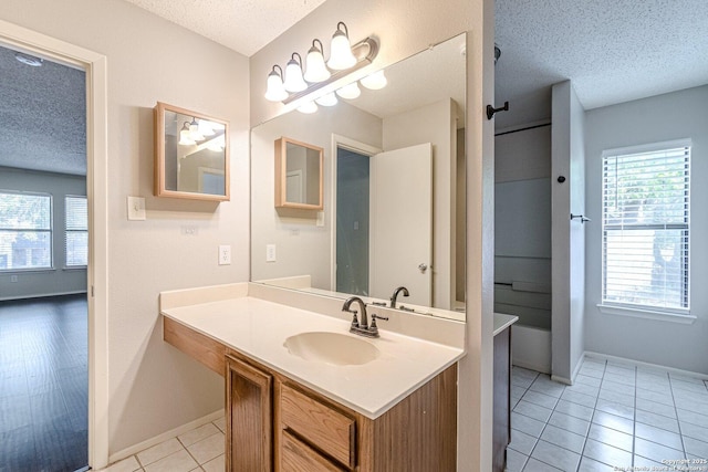 bathroom featuring tile patterned floors, a textured ceiling, and plenty of natural light